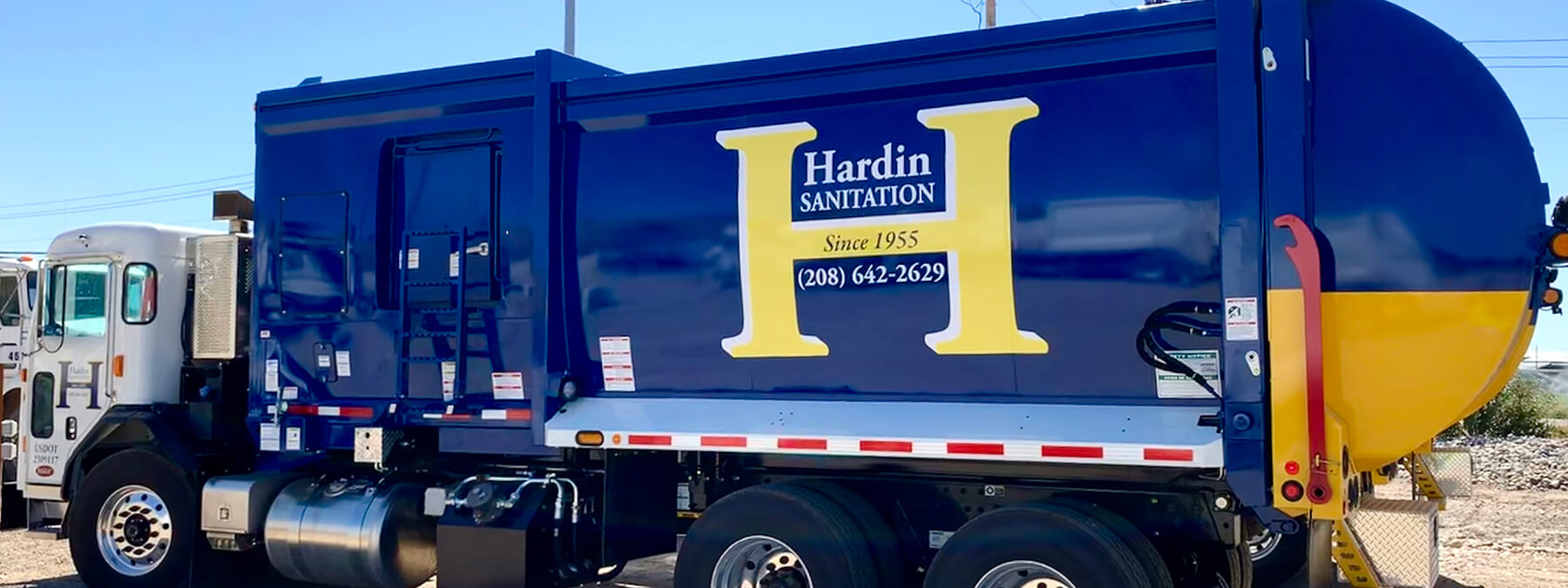 Photo of a Hardin Sanitation Truck driving down a road.
